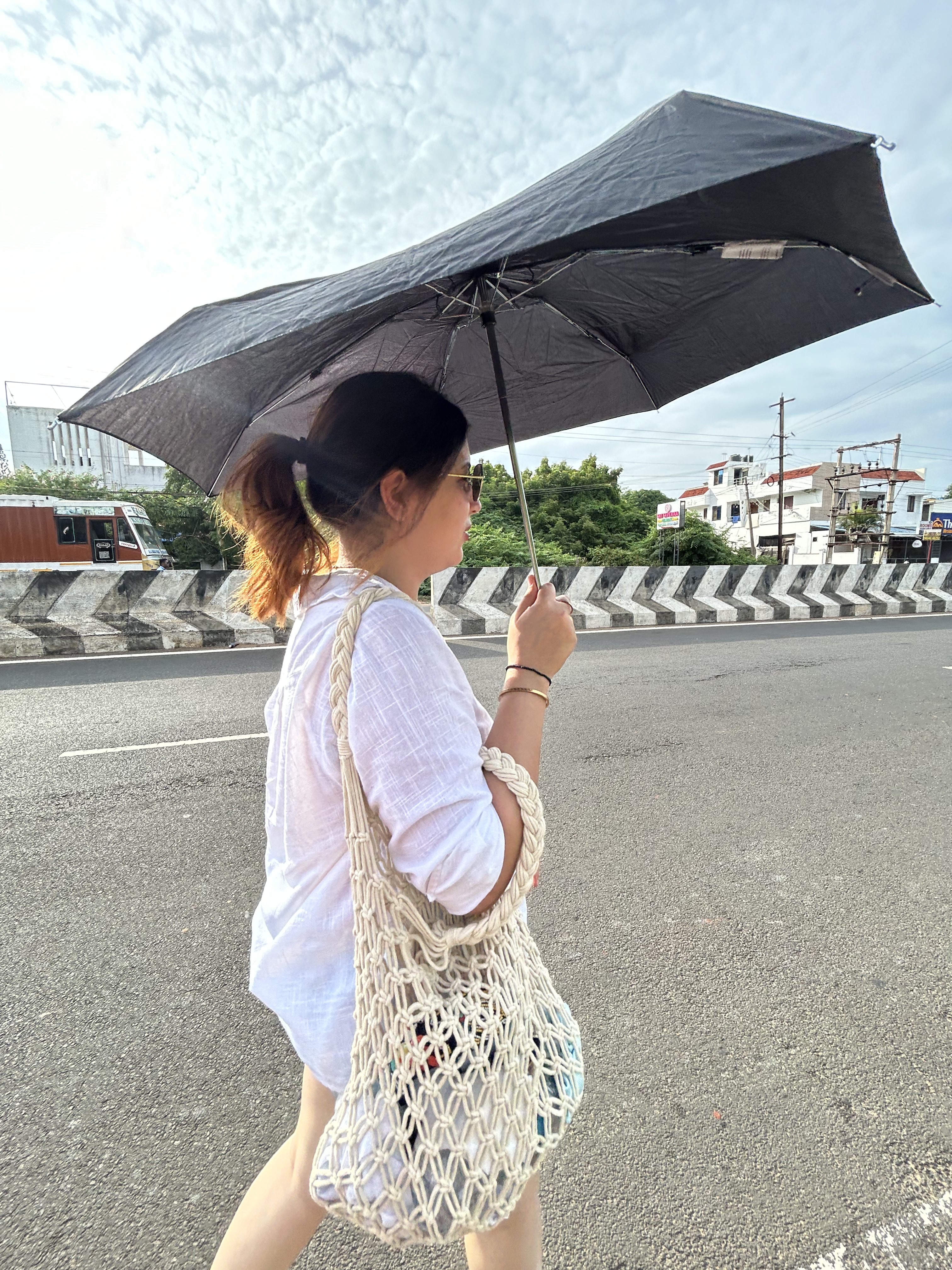 Walking a roadside with an umbrella