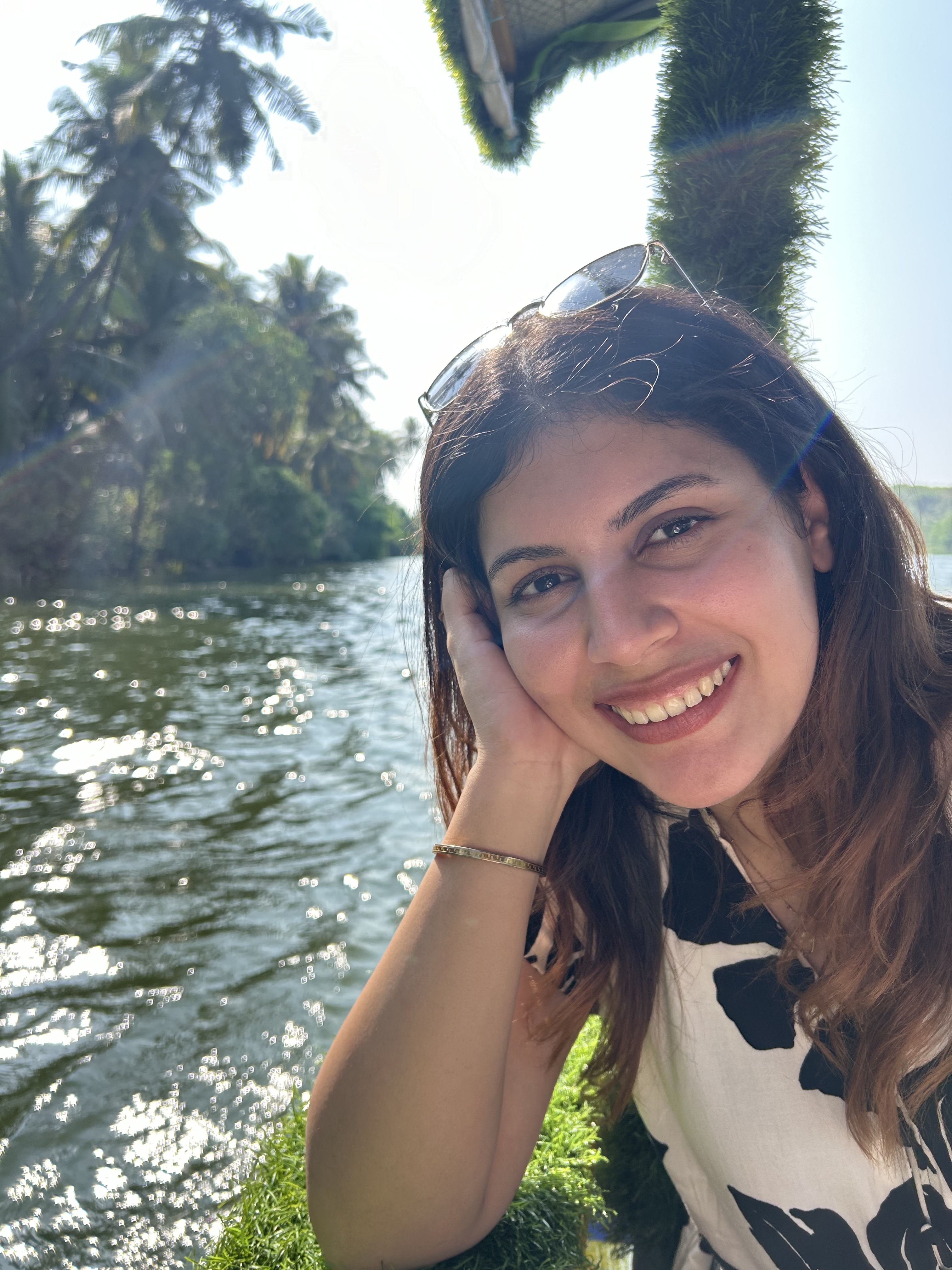 Latika by the water, resting her chin on her hand
